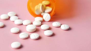 An orange container of white pills, aspirin video