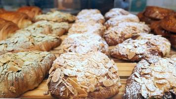 Panning view of many loaves of baked almond bread in a bakery display case video