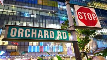 Orchard Rd green street sign at night in retail district of Singapore video