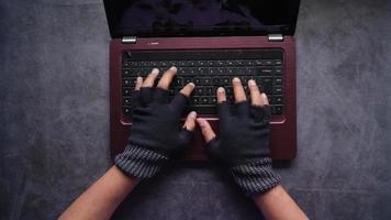 mani con guanti digitando su il computer portatile video
