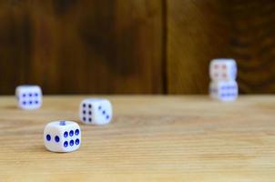 A few dice lies on the surface of natural wood. Items for generating numbers from one to six in the form of points that are painted on the side of cubes. The concept of gambling photo