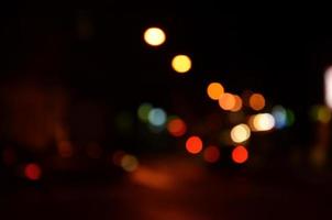 Blurred night scene of traffic on the roadway. Defocused image of cars traveling with luminous headlights. Bokeh Art photo