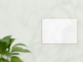 Horizontal wooden frame mockup on white wall. Poster mockup. Clean, modern, minimal frame. Empty frame Indoor interior, show text or product. frame mockup with shadow and plant. 3d rendering. photo