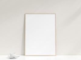 Interior poster mockup with photo frame leaning against the white wall. Minimalist photo frame mockup. Empty frame stands on white table. 3d rendering.