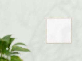 Square wooden frame mockup on white wall. Poster mockup. Clean, modern, minimal frame. Empty frame Indoor interior, show text or product. frame mockup with shadow and plant. 3d rendering. photo