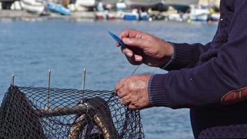 Fischer repariert seine Netze am Strand video