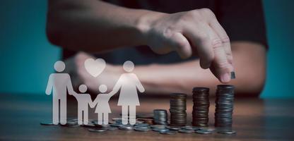 Businessman take a coin money into stack with paper family beside for education, donation, saving, charity, family finance plan concept, fundraising, superannuation, financial crisis concept. photo