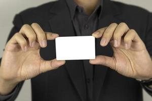 la mano de un hombre que sostiene una tarjeta blanca para el diseño de concepto entre tarjetas, y un hombre de dardo inteligente que muestra una tarjeta de identificación falsa blanca sobre fondo blanco. foto