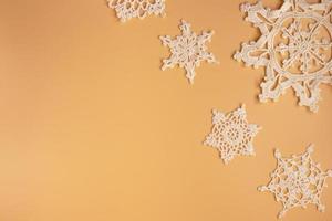 Top view of handmade white crochet  snowflakes on orange background. Merry Christmas and happy new year concept. photo