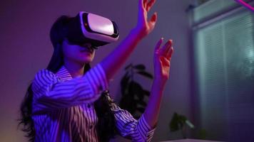 niña que aplica auriculares de realidad virtual durante el trabajo en casa por la noche, concepto de tecnología moderna