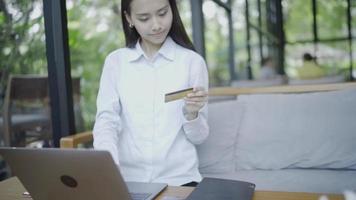 Businessmen or female freelancers Working in front of a laptop Use your credit card to shop online Work outside the office at a restaurant or coffee shop. video