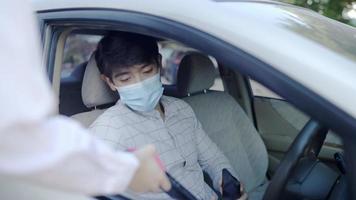 homens asiáticos estavam dirigindo para tomar café em um drive-thru durante o surto de covid-19. video
