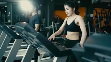 Athletic Sports Man And Woman Wearing Running on a Treadmill. Energetic Female Athlete Training in the Gym video