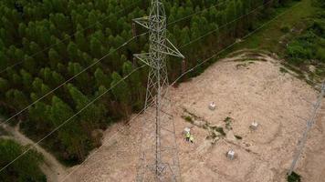 engenheiros ambientais masculinos e femininos inspecionam a floresta para o desenvolvimento do canteiro de obras da fundação do poste de alta tensão. video