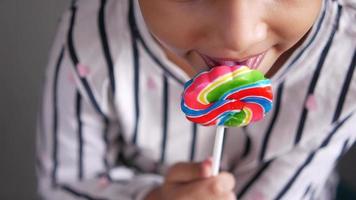 A kid licking a lollipop, hard candy, sugar video