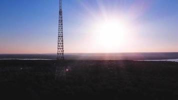 Aerial view of TV tower against backdrop of sunset landscape. video