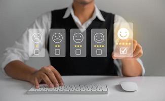 empresario presionando la calificación de emoticonos faciales en la pantalla táctil virtual para brindar experiencia de servicio. concepto de satisfacción y servicio al cliente. foto