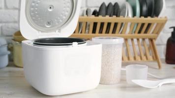 Electric rice cooker on wooden counter-top against ceramic backsplash video