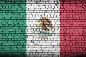 Mexico flag is painted onto an old brick wall photo