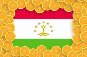 Tajikistan flag in fresh citrus fruit slices frame photo