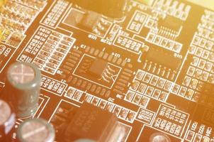 A toned macro image of a computer board with many small technological elements. Extremely shallow depth of field. Abstract technological background photo