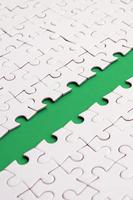 The green path is laid on the platform of a white folded jigsaw puzzle. Texture image with copy space for text photo