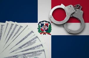 Dominican Republic flag with handcuffs and a bundle of dollars. The concept of illegal banking operations in US currency photo