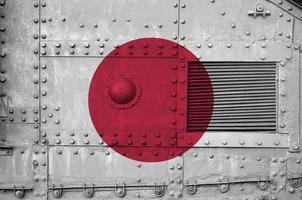 Japan flag depicted on side part of military armored tank closeup. Army forces conceptual background photo