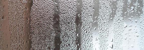The texture of a misted glass with a lot of drops and condensation flows. Background image photo