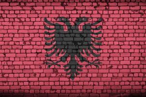 la bandera de albania está pintada en una vieja pared de ladrillos foto