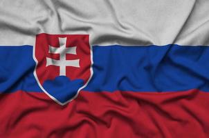 Slovakia flag is depicted on a sports cloth fabric with many folds. Sport team banner photo