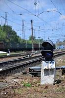 Railway traffic light semaphore against the background of a day railway landscape. Signal device on the railway track photo