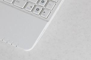 The element of the white compact modern netbook. Photo with a fragment of the computer keyboard with flat white buttons with copy space
