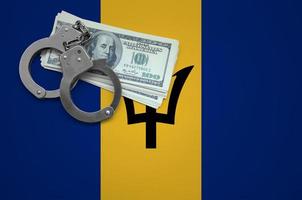Barbados flag with handcuffs and a bundle of dollars. The concept of breaking the law and thieves crimes photo