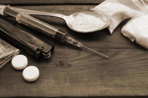 A lot of narcotic substances and devices for the preparation of drugs lie on an old wooden table photo