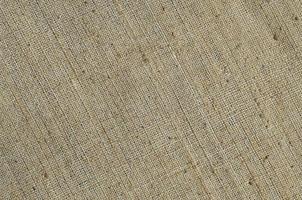 Texture of a gray canvas made of old and coarse burlap. Top view photo