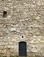 textura de la pared de piedra medieval y de la puerta de metal vieja foto