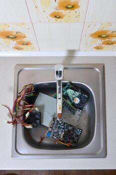 Hardware in kitchen sink under the water flow computer cleaning metaphoric concept photo