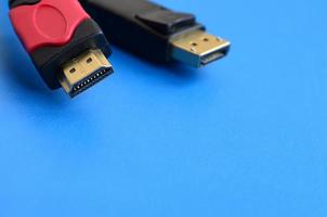 Audio video HDMI computer cable plug and 20-pin male DisplayPort gold plated connector for a flawless connection on a blue background photo