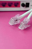 Internet router and Internet cable plugs lie on a bright pink background. Items required for Internet photo