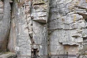 Light coarse natural rock stone background. Mining cliff rough front surface. Big limestone stack backdrop. Heavy grunge damaged granite block texture photo