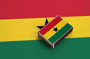 la bandera de ghana está representada en una caja de fósforos que se encuentra en una bandera grande foto