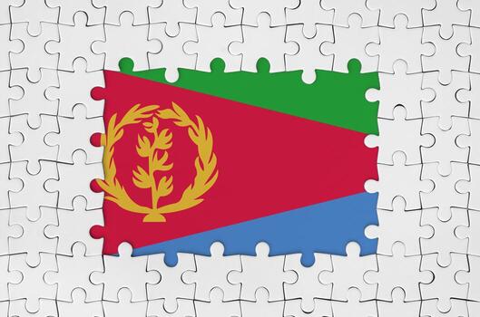 Eritrea flag in frame of white puzzle pieces with missing central part photo