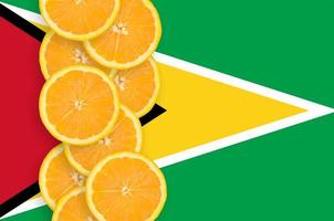 Guyana flag and citrus fruit slices vertical row photo