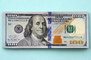 US dollar bills of a new design with a blue stripe in the middle is lies on a light blue background photo