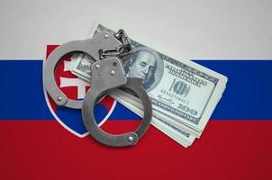 Slovakia flag with handcuffs and a bundle of dollars. Currency corruption in the country. Financial crimes photo