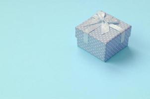 Small blue gift box lie on texture background of fashion pastel blue color paper photo