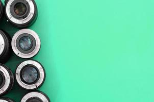 Several photographic lenses lie on a bright turquoise background. Copy space photo