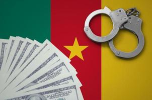 Cameroon flag with handcuffs and a bundle of dollars. The concept of illegal banking operations in US currency photo