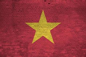 Vietnam flag depicted in paint colors on old brick wall. Textured banner on big brick wall masonry background photo